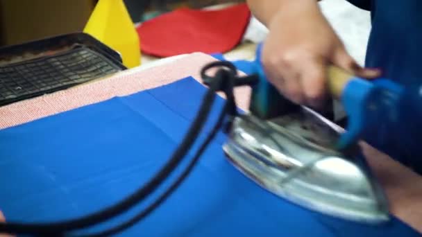 Eine Frau bügelt in einer Bekleidungsfabrik. Nahaufnahme — Stockvideo