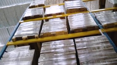 Adres deposu. Bitmiş ürünleri saklamak için raflara istiflenmiş paletler. Yakın çekim.