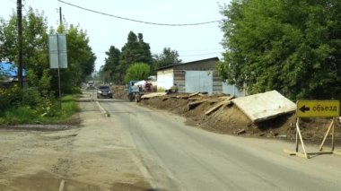 Taşradaki yol. Yol tamiri. Arabalar yolun tamir bölümlerinin etrafından dolaşır.