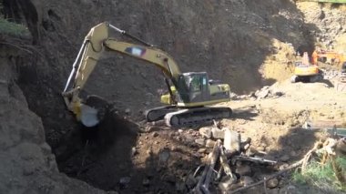 Toprağı kazmak ve boşaltmak için kazı makinesi. Kazı makinesi çalışıyor. Güneşli günlerde kumsalda madencilik kampı