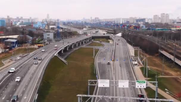 The road leading to different sides of the city. Cars drive along the pathway to the city. Movement of cars aerial view in the sunny day — Stock Video