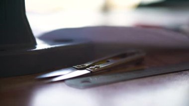 Demir makas ahşap bir masanın üzerinde yatıyor. Dikiş dikmek. Görüntüyü kapat