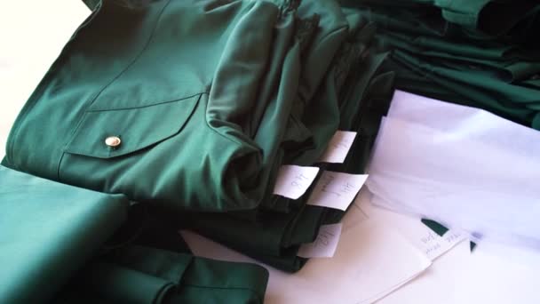 Zelené obleky stejného typu v různých velikostech. Na stole jsou ručně vyráběné věci, pohled zblízka — Stock video