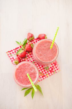 Çilek güler yüzlü ve tüpler ile iki cam kavanoz