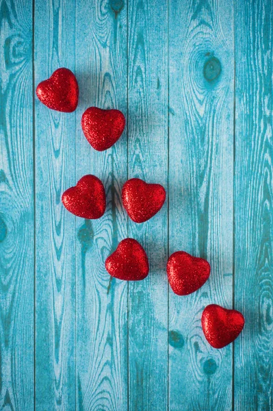 Mavi ahşap arka plan üzerinde kırmızı Kalpler