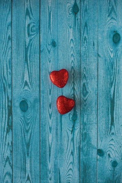 ahşap doku ile mavi bir arka plan üzerinde iki kırmızı kalp