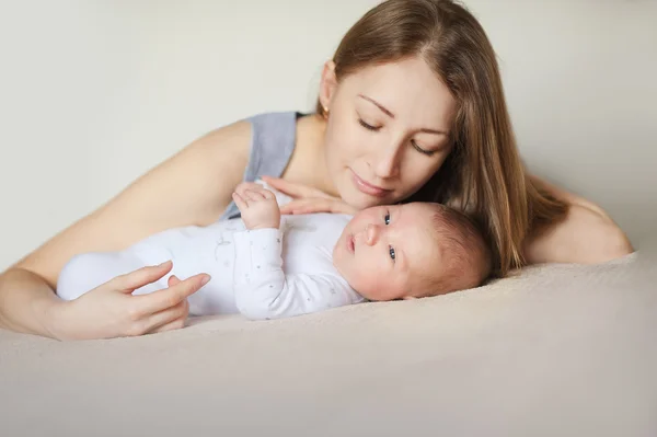 Mãe e criança em uma cama branca . — Fotografia de Stock