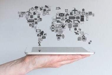 Küresel mobil cihazlar ve nesnelerin interneti kavramı. Nötr arka plana sahip modern tablet veya akıllı telefon tutan el.