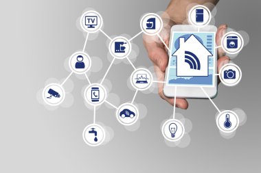 Nötr arka planda modern akıllı telefon tutan el. Bağlı cihazlarla akıllı ev otomasyon konsepti