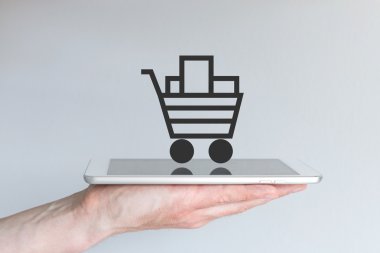 Sembol olarak online alışveriş sepeti ile el tutma akıllı telefon
