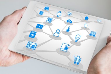 Male holding tablet in both hands with internet of everything (IOT) concept