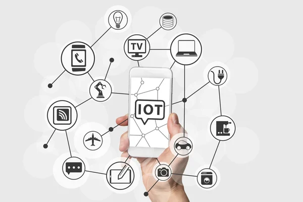 Internet das Coisas (IOT) conceito com mão segurando moderno telefone inteligente branco e prata . — Fotografia de Stock