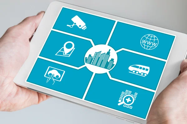 Smart city concept. Hand holding tablet or smart phone with icons of connected devices. — 图库照片