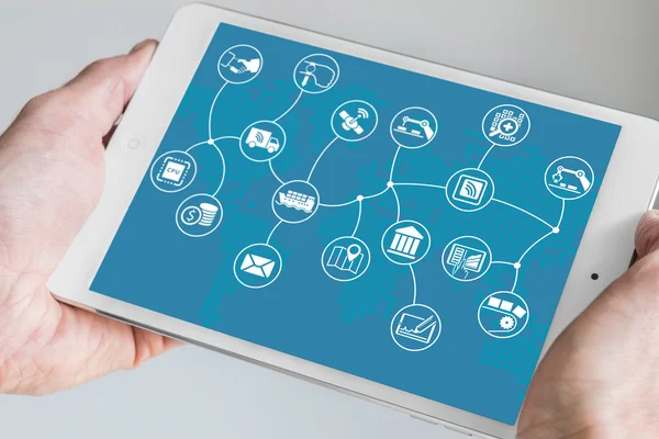 Mano sosteniendo tableta moderna. Modelo de negocio de Internet de las cosas (IOT) y flujo con mapa del mundo sobre fondo azul . — Foto de Stock