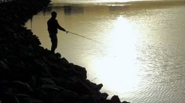 Balıkçı siluet şehir gün batımında