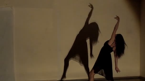 Woman dancing with shadow on wall — Stock Video