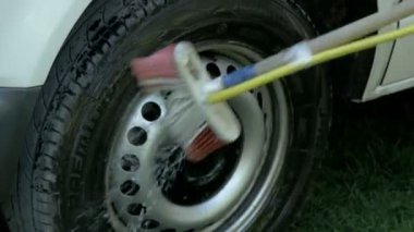 Adam arabayı yıkıyor.