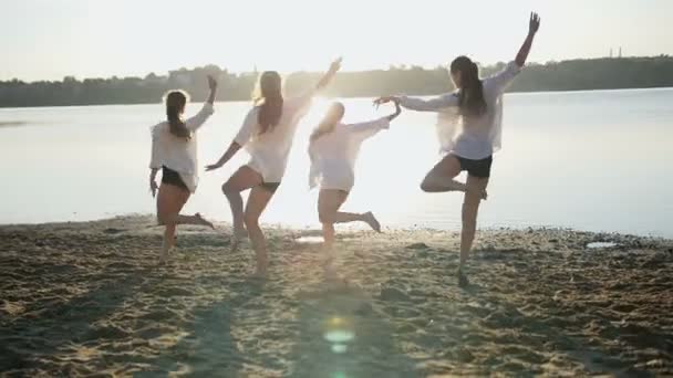 Actuación de baile de cuatro chicas en la playa de arena cerca del lago al amanecer — Vídeos de Stock