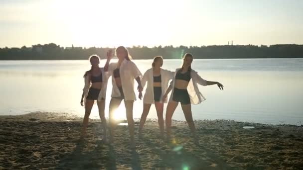 Actuación de baile de cuatro chicas en la playa de arena cerca del lago al amanecer — Vídeos de Stock