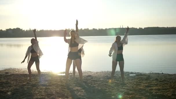 Dansvoorstelling van vier meisjes op zand strand in de buurt van lake bij dageraad — Stockvideo