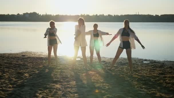 Actuación de baile de cuatro chicas en la playa de arena cerca del lago al amanecer — Vídeos de Stock