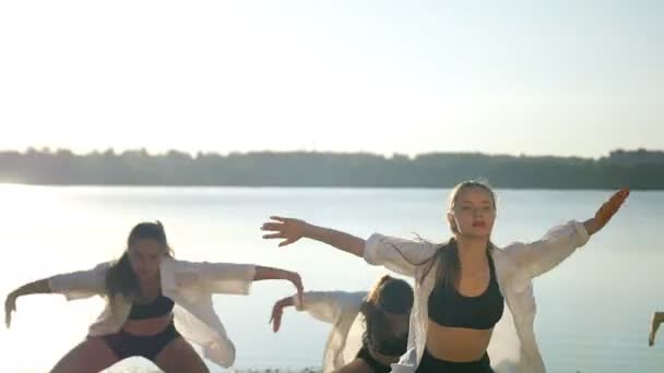 Actuación de baile de cuatro chicas en la playa de arena cerca del lago al amanecer — Vídeo de stock