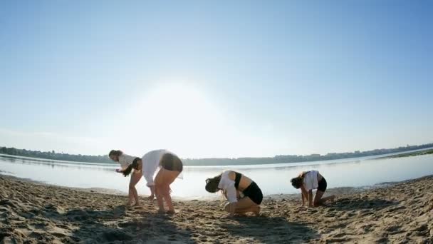 Tanzperformance von vier Mädchen am Sandstrand in der Nähe des Sees im Morgengrauen — Stockvideo