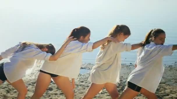 Dance performance of four girls on sand beach near lake at dawn — Stock Video