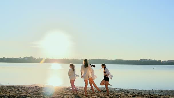 Dansföreställning av fyra tjejer på sandstrand nära sjön i gryningen — Stockvideo