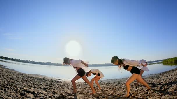 Χορευτική παράσταση των τεσσάρων κοριτσιών στην άμμο παραλία κοντά στη λίμνη την αυγή — Αρχείο Βίντεο