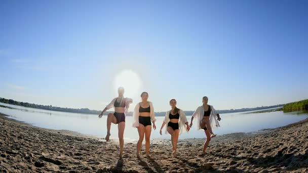 Dansvoorstelling van vier meisjes op zand strand in de buurt van lake bij dageraad — Stockvideo