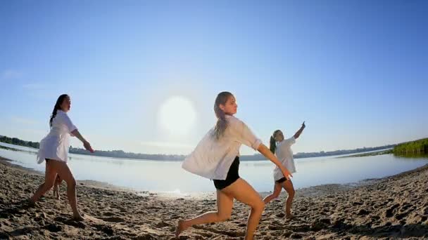 Actuación de baile de cuatro chicas en la playa de arena cerca del lago al amanecer — Vídeos de Stock