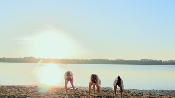 黎明在湖边的沙滩上的四个女孩的舞蹈表演。 — 图库视频影像