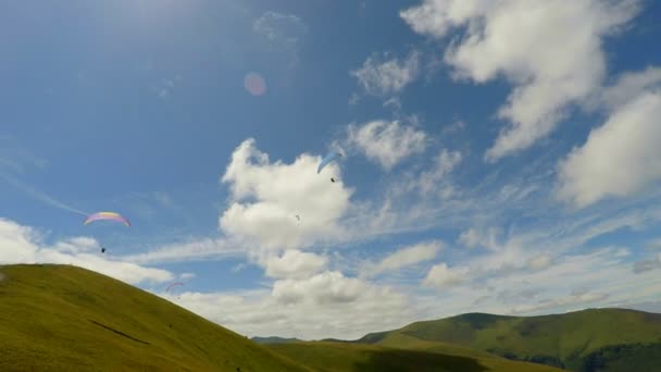 Paragliders flyga nära fantastiska gröna berg — Stockvideo