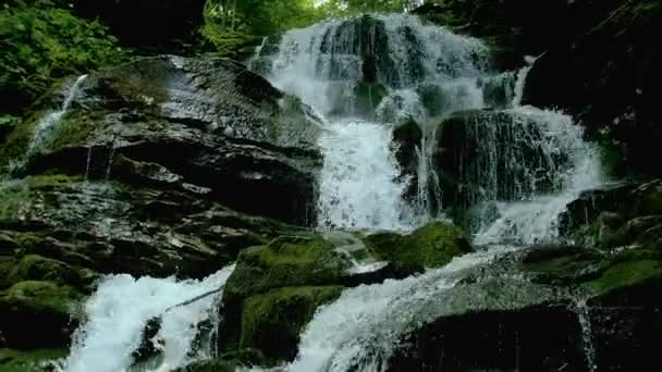 Trapsgewijze waterval splash op stenen in het bos tussen bergen. — Stockvideo