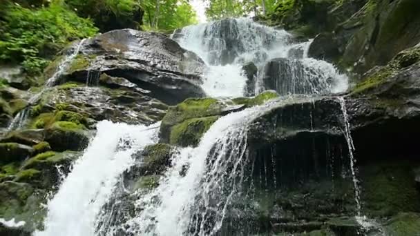 Cascade vattenfall stänk på stenar i skogen bland bergen. Slow motion. — Stockvideo