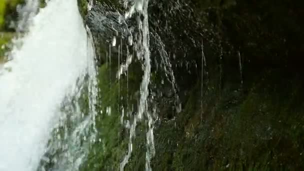 Visa under vattenfall stänk på stenar i skogen bland bergen. Slow motion. — Stockvideo