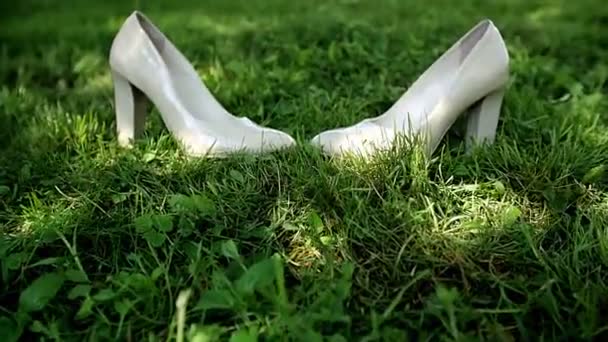 Brides white wedding shoes in the grass. — Stock Video