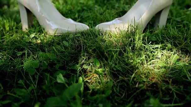 Bruiden witte Trouwschoenen in het gras. — Stockvideo