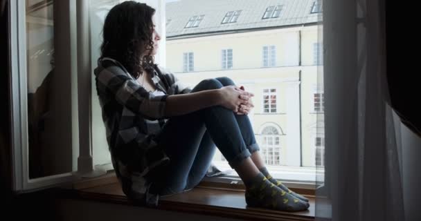 Jeune femme assise sur le rebord de la fenêtre et bénéficiant d'une vue sur la vieille ville. Silhouette de détente Fille à l'air frais à la maison — Video
