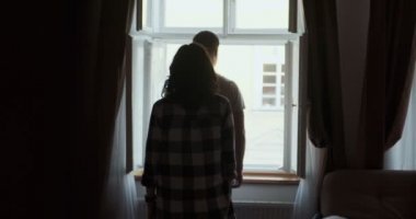 Genç bir çift, evdeki pencerenin yanında kalıyor. Mutlu genç aşıklar evde birlikte vakit geçirmenin tadını çıkarırlar.