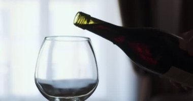 Şarap kadehini süper yavaş çekimde kırmızı şarapla doldurun. Kadehe kırmızı şarap dök. Kırmızı şarap camda güzel bir dalga oluşturur.