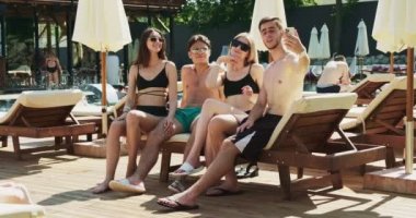 Bir grup arkadaş bilardoda eğleniyor. Havuz kenarında otururken akıllı telefondan selfie çekiyoruz. Yaz partisi yüzme havuzunun yanında