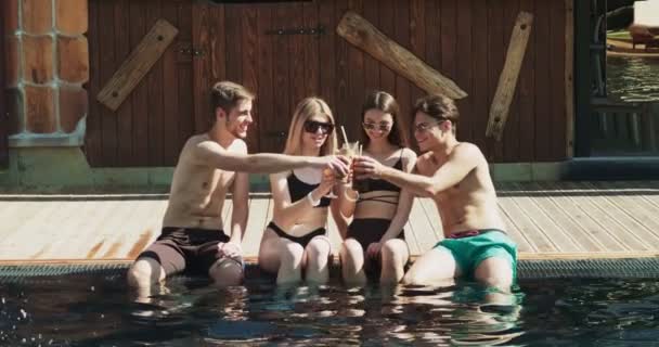 Un grup de prieteni se distrează la piscină. Oamenii beau cocktail-uri de vară la un hotel de lux în vacanță tropicală. Ochelari de petrecere însorită cu cocktail-uri de fructe lângă piscină Clip video