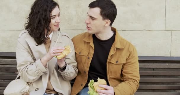 Couple doux ont des vacances dans la vieille ville européenne. Les jeunes amoureux heureux aiment passer du temps ensemble. Manger sur le banc de la nourriture de rue locale Séquence Vidéo