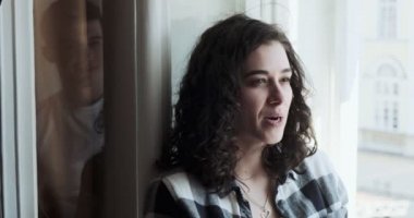 Pencere kenarında oturan genç bir çift ve kadın eski kasaba manzarasının tadını çıkarıyorlar. Mutlu genç aşıklar evde birlikte vakit geçirmenin tadını çıkarırlar.