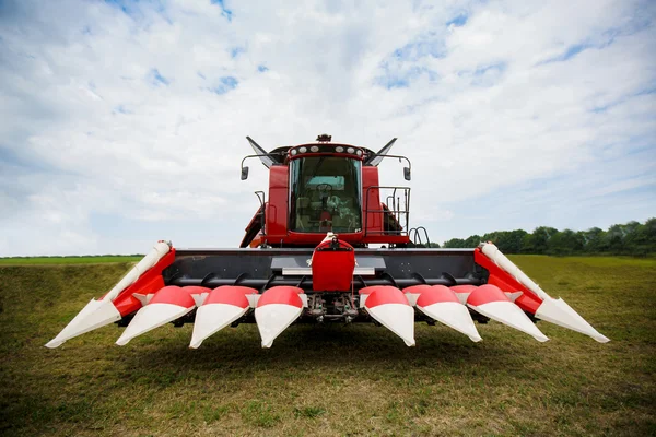 Modern teknoloji kırmızı traktör ilkbaharda çiftlikte yeşil tarla sürüyor. Buğday eken hasatçı.. — Stok fotoğraf