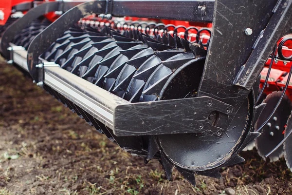 Άροτρο σύγχρονης τεχνολογίας κόκκινο τρακτέρ από κοντά σε αγροτικές γαίες μηχανισμός — Φωτογραφία Αρχείου
