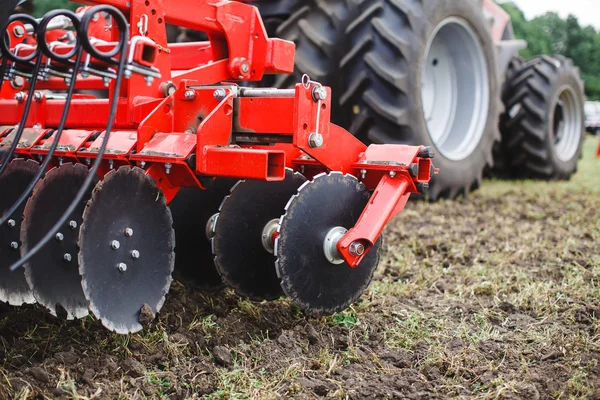 Tractor rojo moderno en el sector agrícola; mecanismo; arado — Foto de Stock