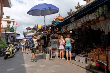 Ubud, Bali, Endonezya - 22 Ağustos 2025: Ubud Street Market 'te turistler. Ubud Sanat Pazarı yerel hediyelik eşya ve el sanatları için popüler bir alışveriş merkezidir..